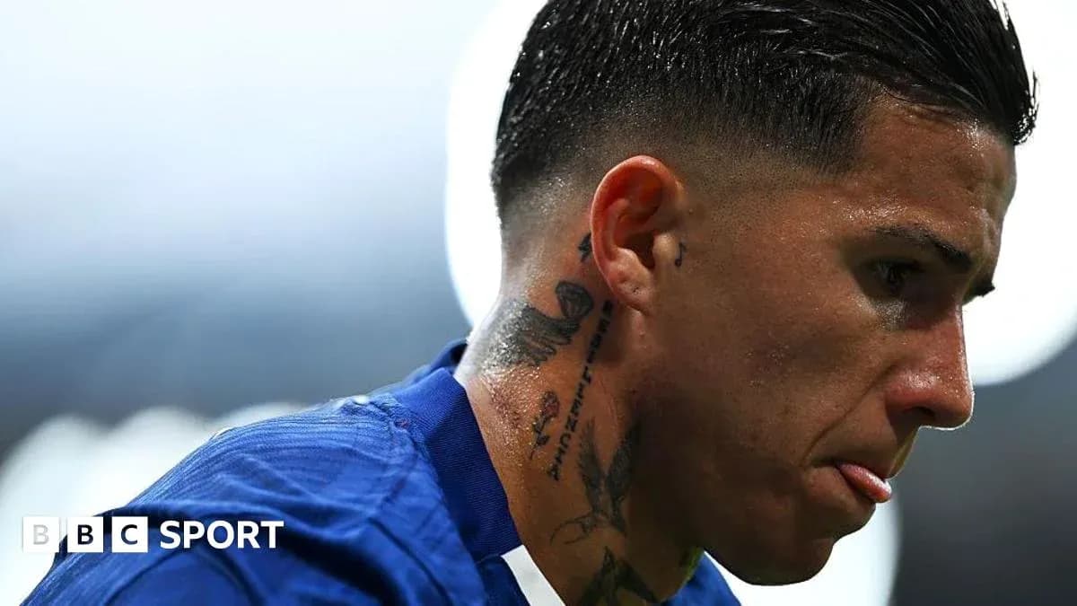 Futbolçu mavi forma ilə sahədə düşüncəli görünür