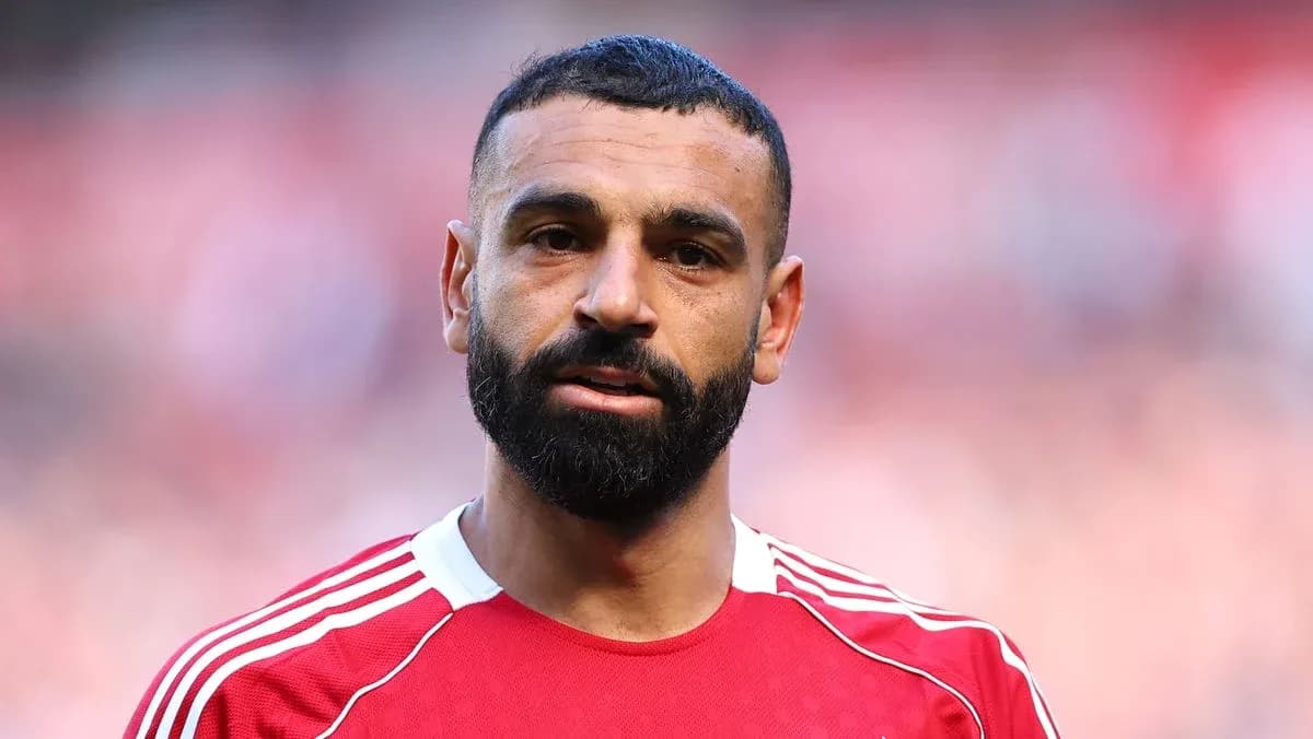 Futbolçu qırmızı formanı geyinib, meydanda durur