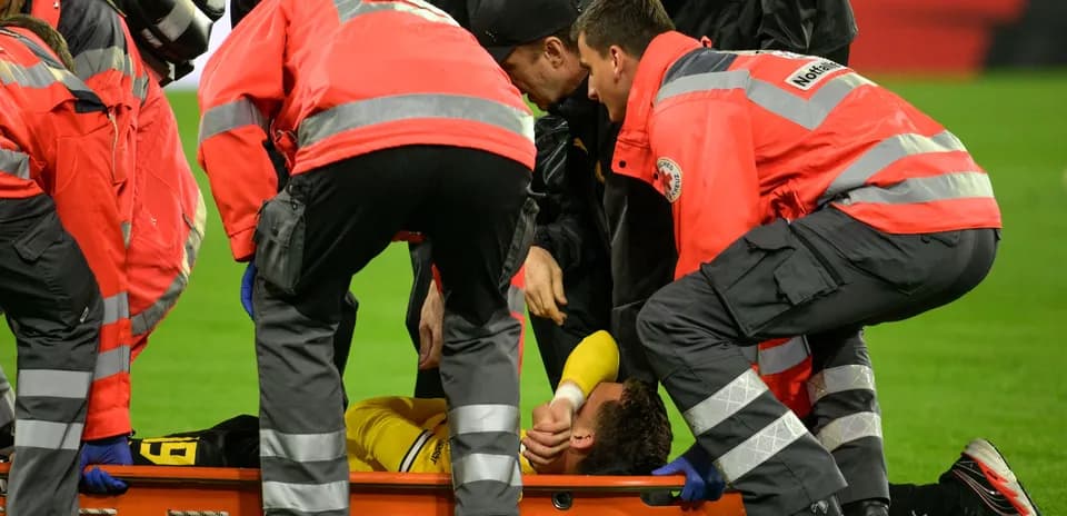 Medical team attending injured player on stretcher