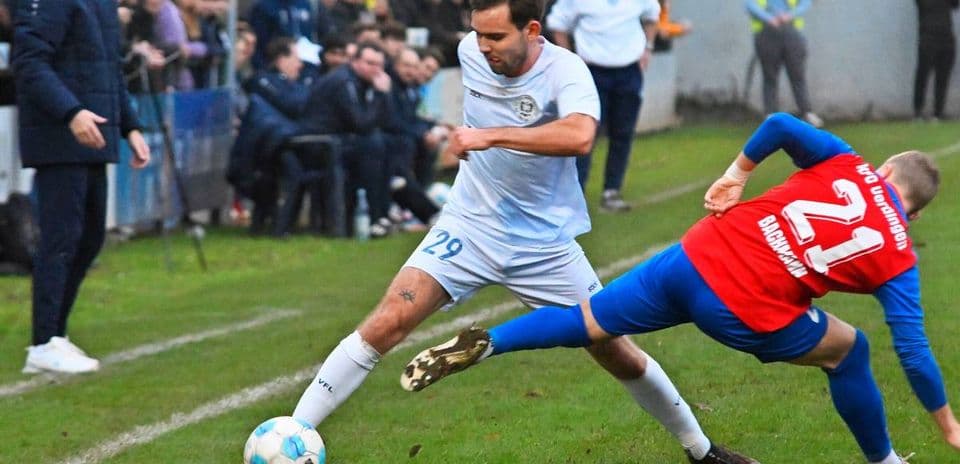Futbol oyunu zamanı iki oyunçu mübarizə aparır