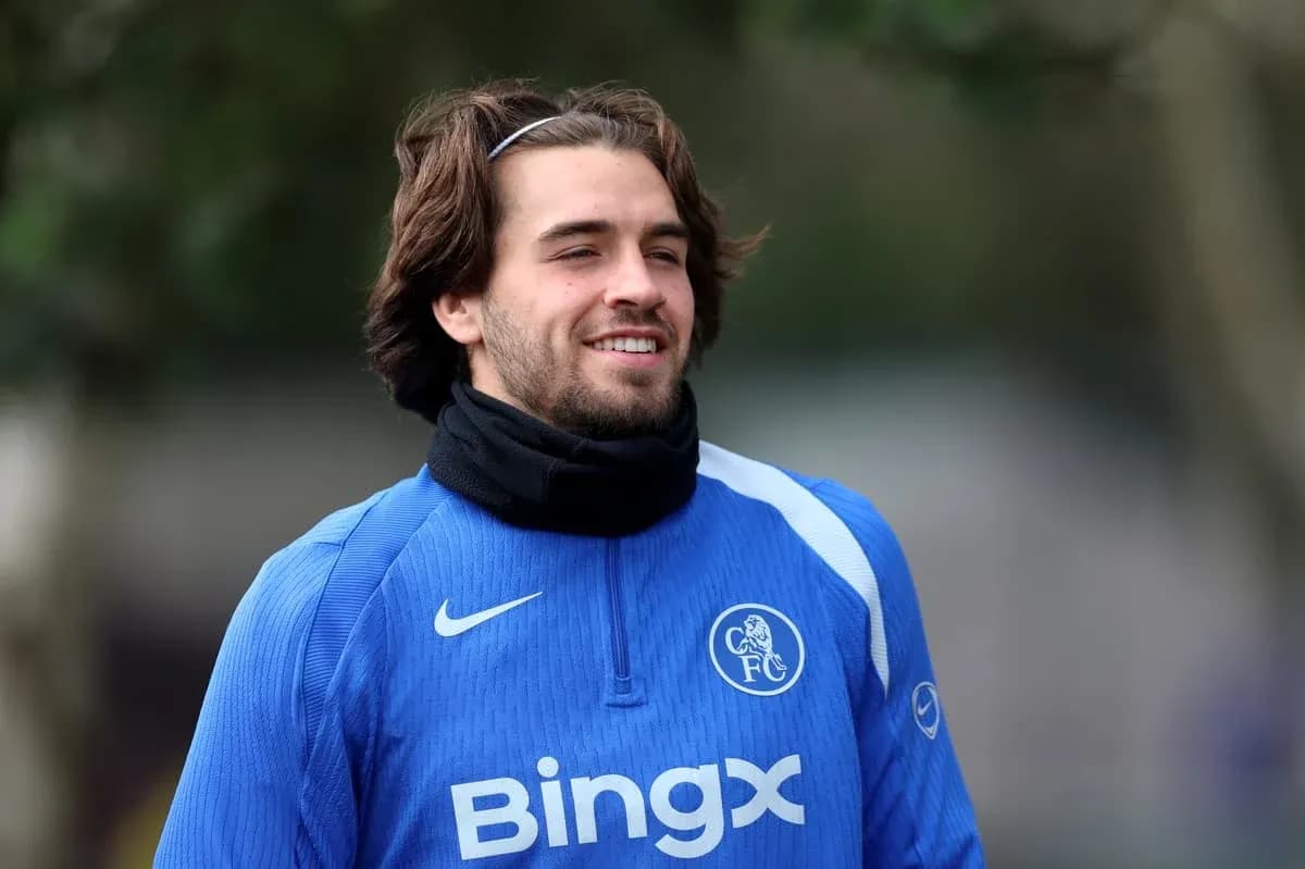 Futbolçu mavi formanı geyinərək gülür