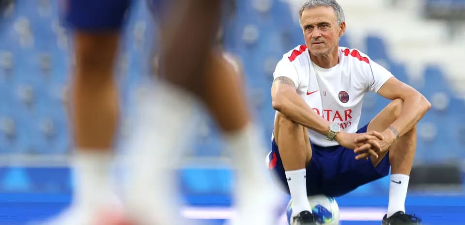 Coach squatting during training session at stadium