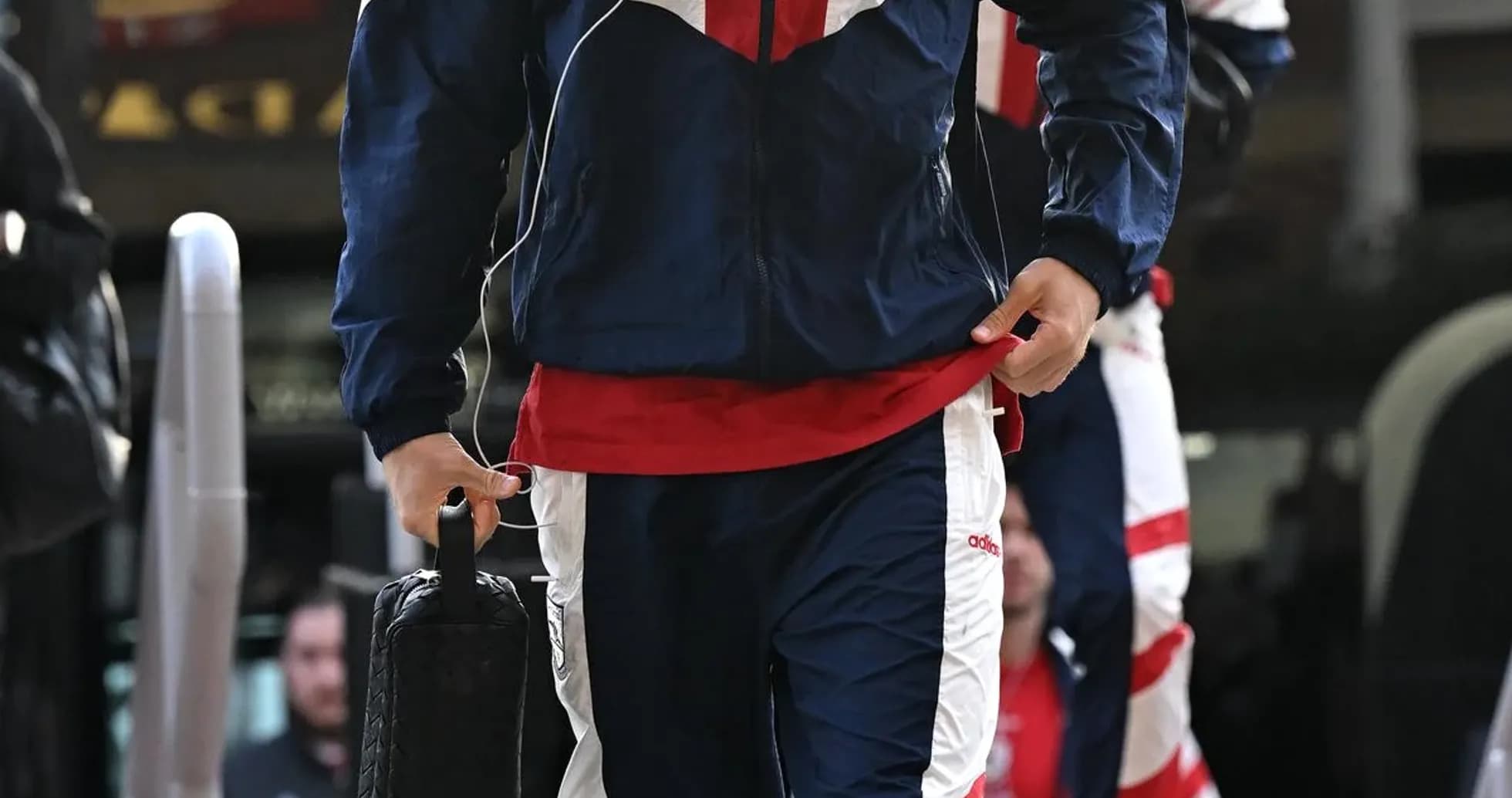 Player in training gear arriving at venue