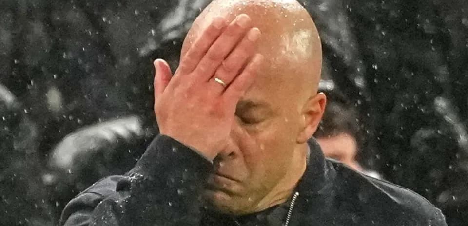 Coach with hand on face in rainy weather