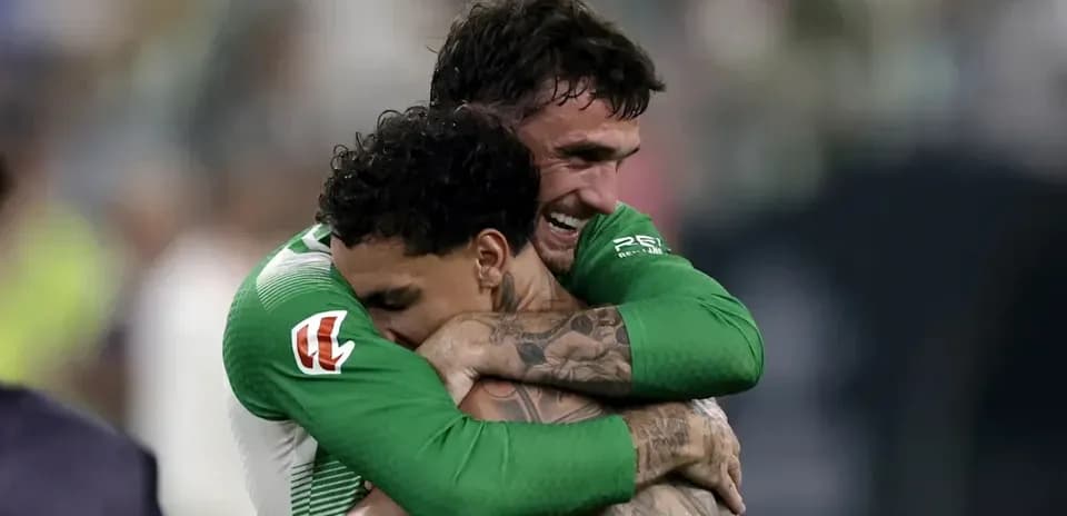Two players celebrating with a hug on field