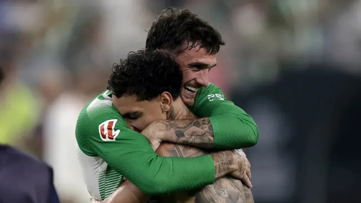 Two players celebrating with a hug on field