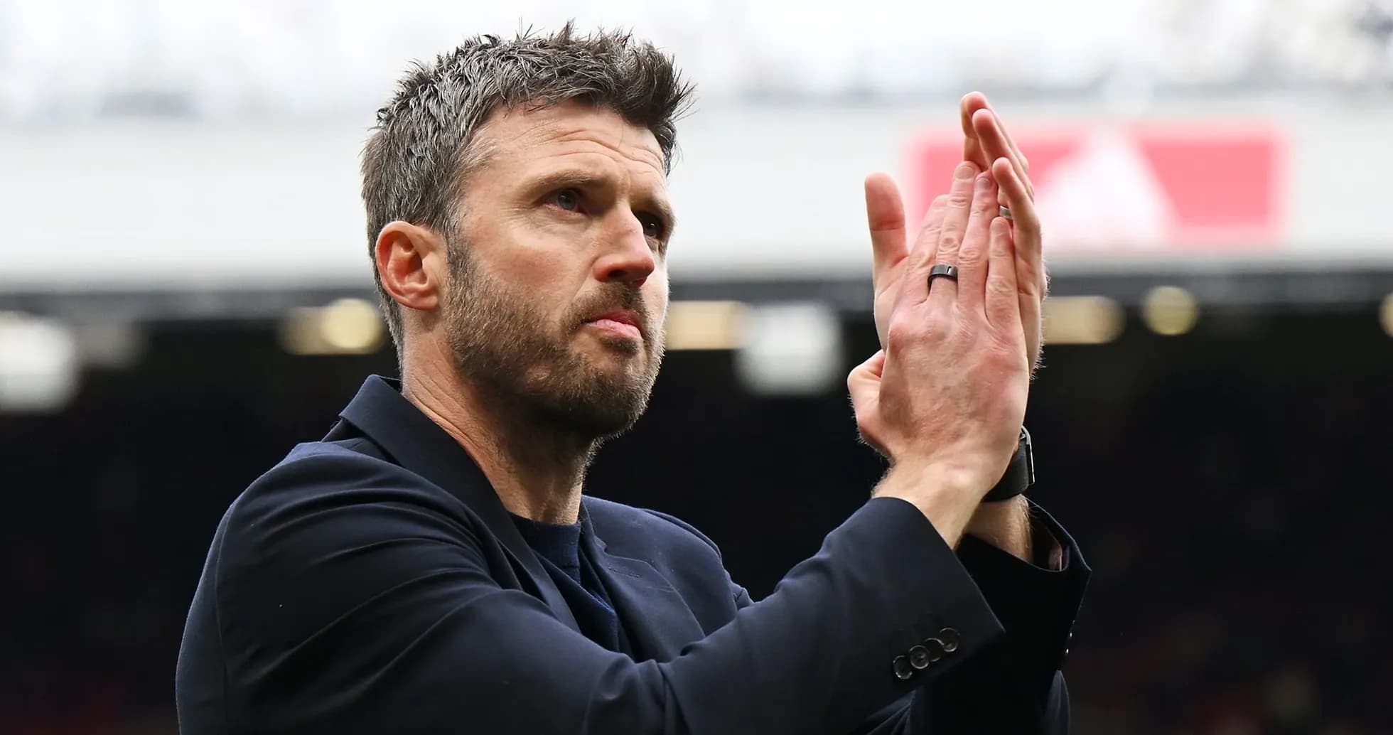 Men's football coach applauding the crowd
