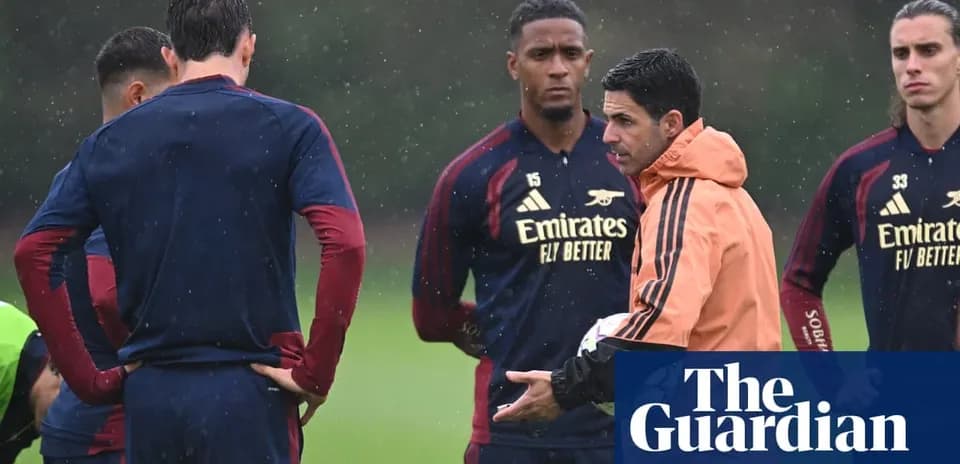Arsenal players listening to coach during training session