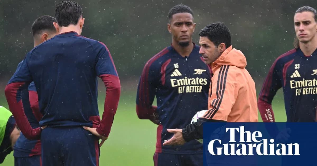 Arsenal players listening to coach during training session