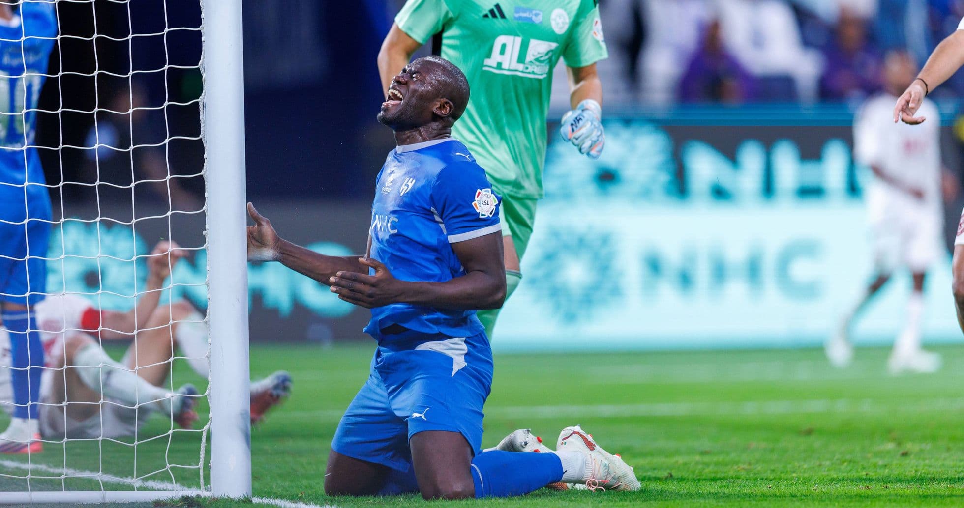 Player kneeling in front of goal post during match