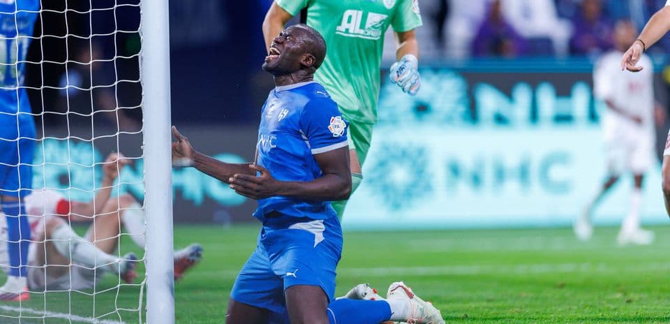Player kneeling in front of goal post during match