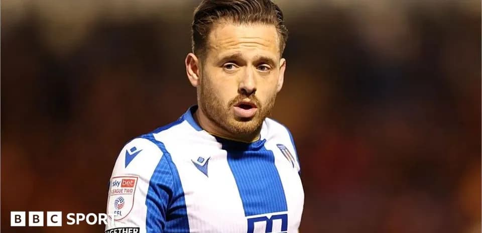 Futbolçu mavi və ağ forma ilə sahədə