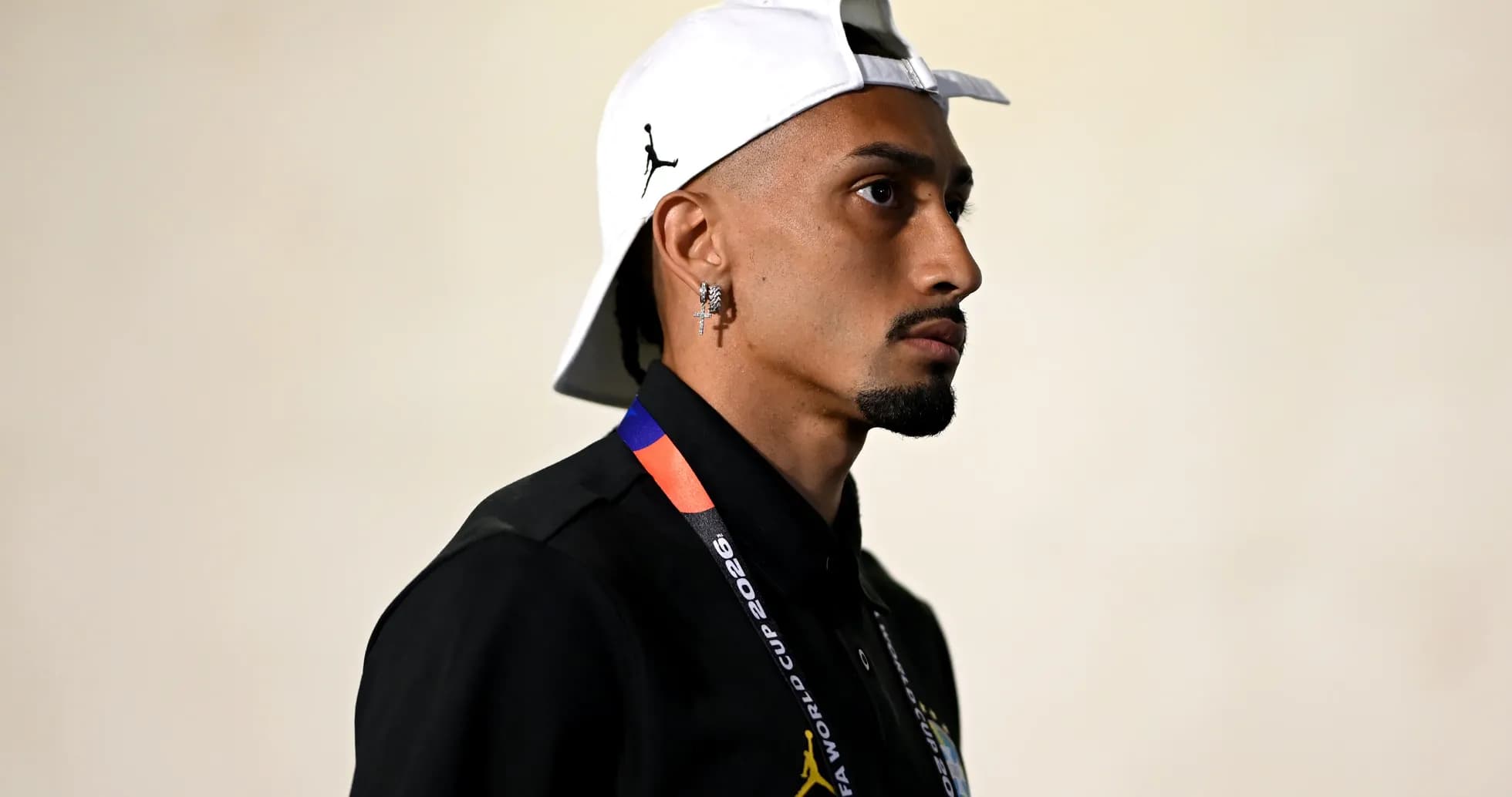Person wearing cap and black shirt with lanyard