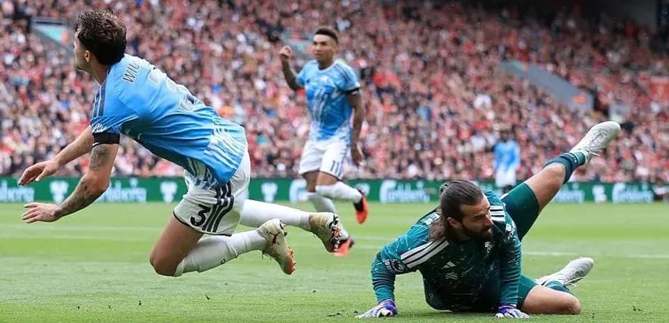 Player falling as goalkeeper makes a save