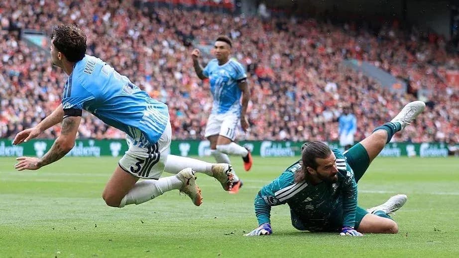 Player falling as goalkeeper makes a save