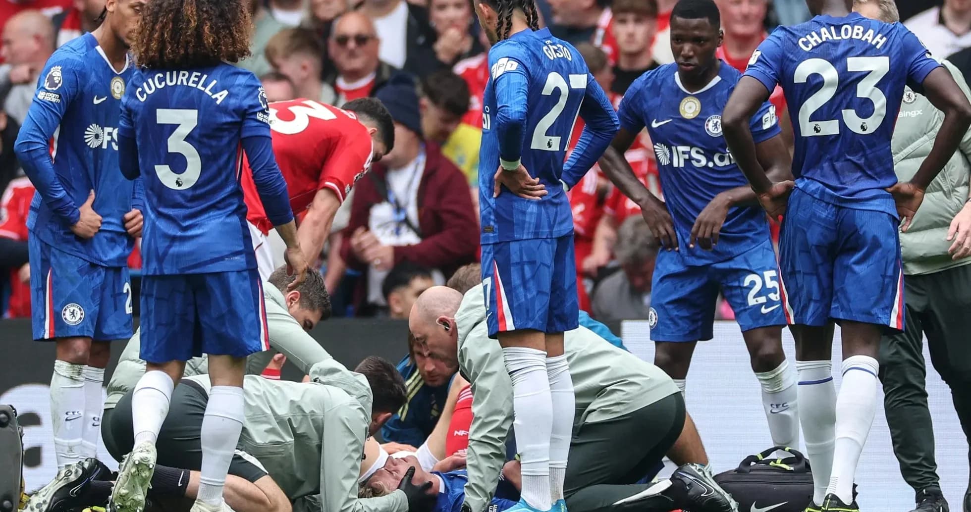 Players gathered around injured teammate on pitch