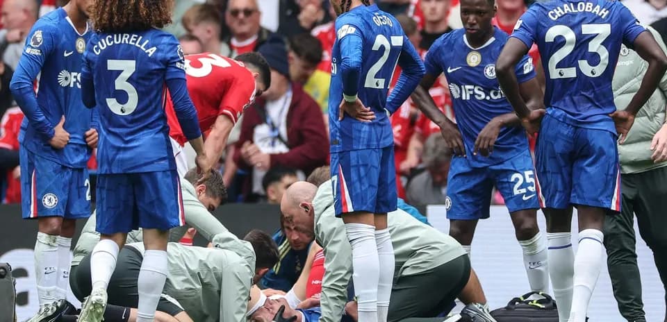 Players gathered around injured teammate on pitch