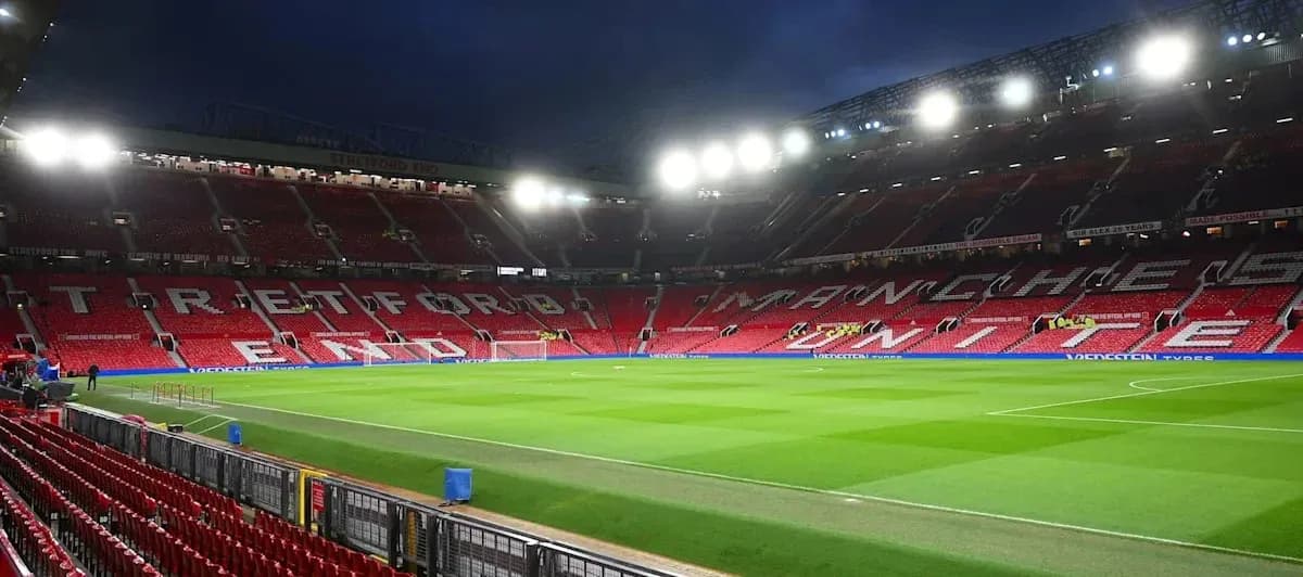 Old Trafford stadium with empty seats and illuminated pitch
