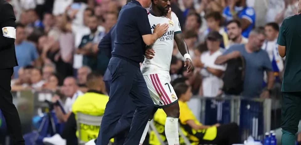 Vinícius Júnior leaving the pitch with coach Carlo Ancelotti