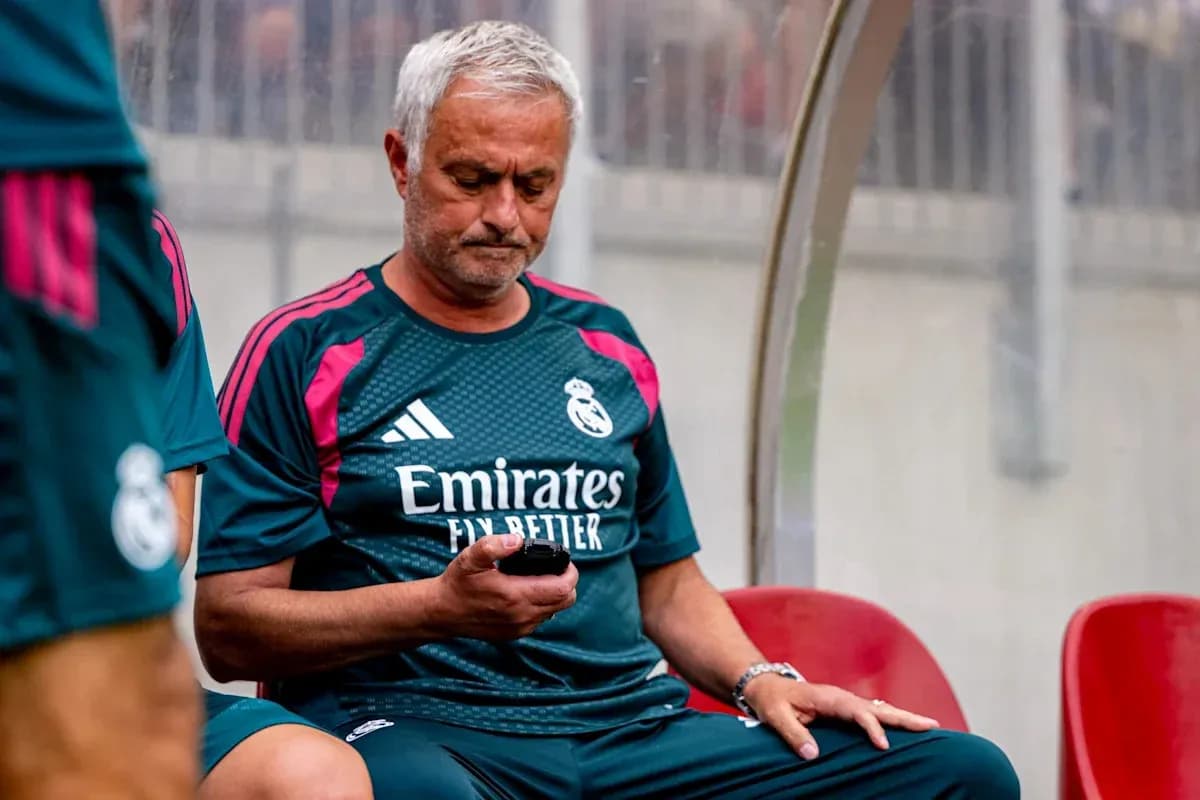 Coach sitting on bench looking at mobile phone