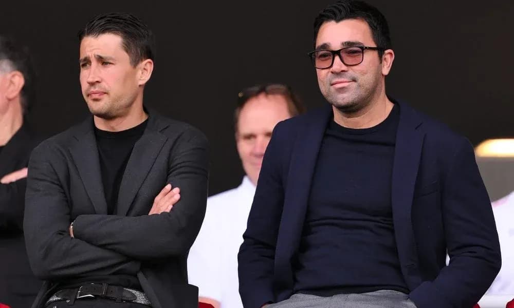 Two men seated in stands during a match