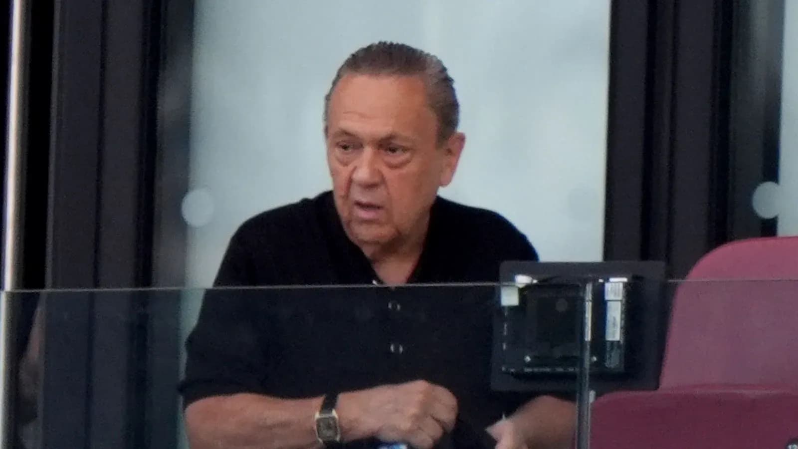 Man in a black shirt in a stadium box
