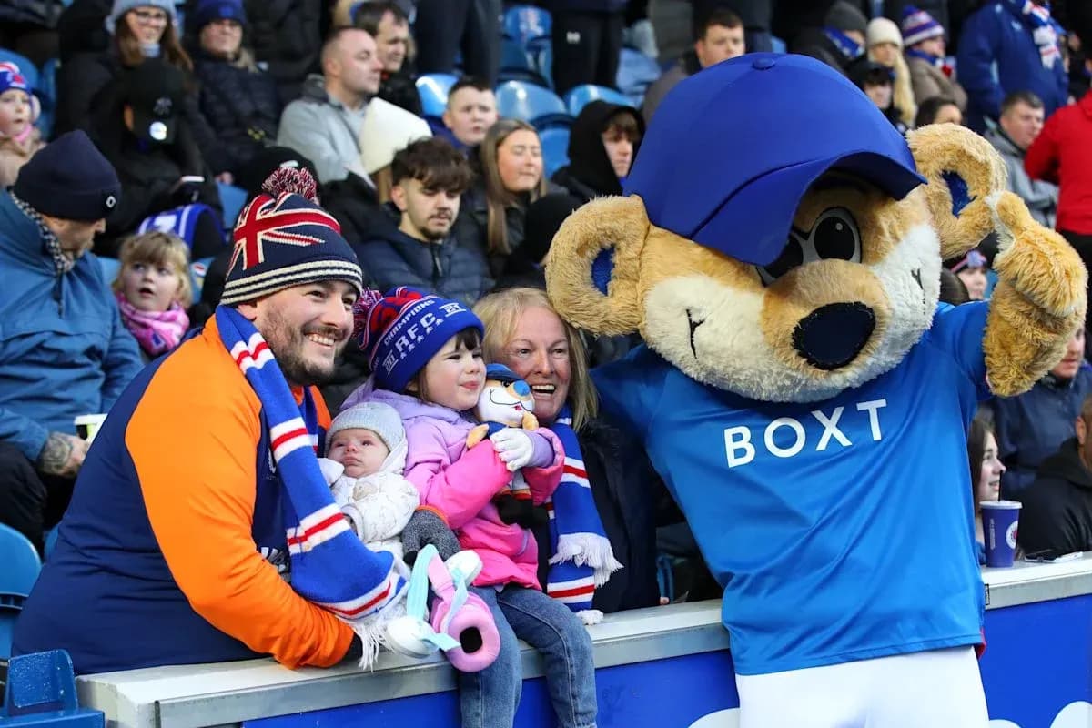 Fan group posing with mascot at football match