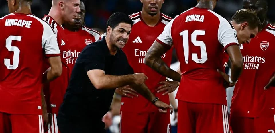 Arsenal players and coach discussing strategy during match
