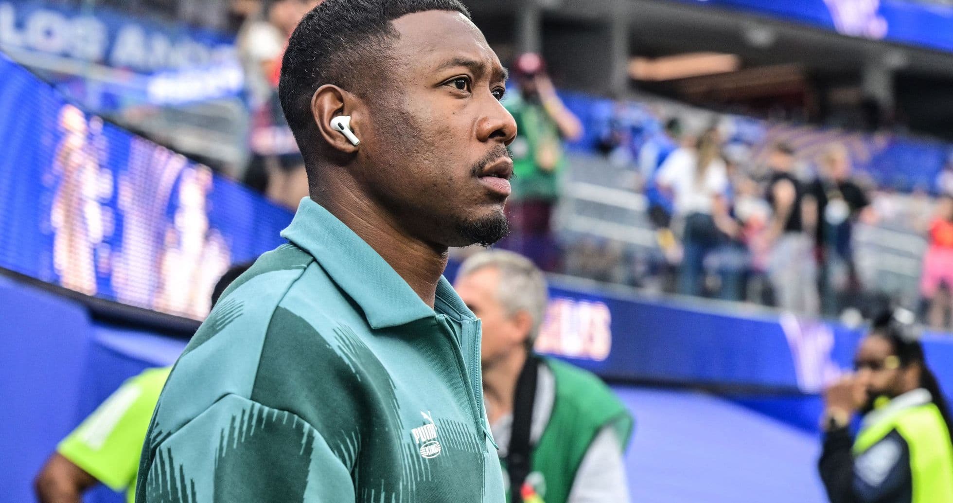 Athlete wearing earbuds near stadium entrance