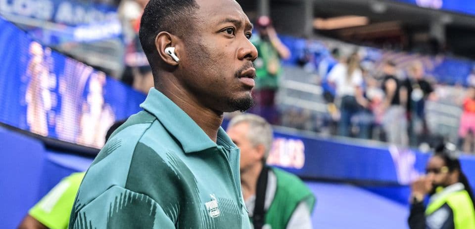 Athlete wearing earbuds near stadium entrance
