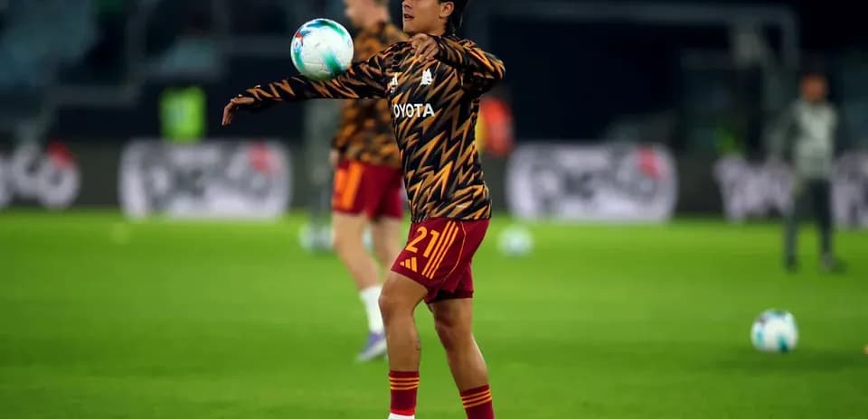 Player warming up and juggling ball on pitch