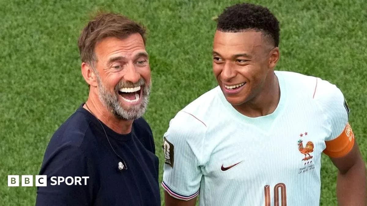 İki şəxs gülərək futbol meydançasında durur