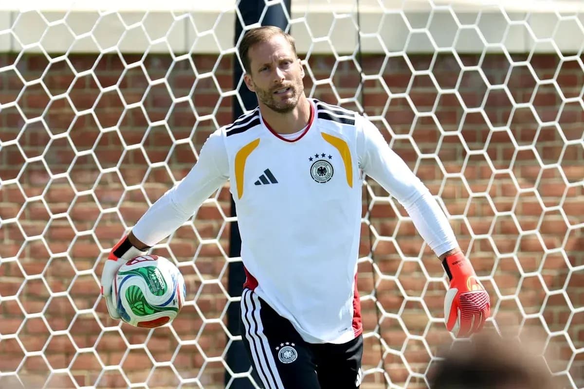 Goalkeeper holding ball in front of goal net