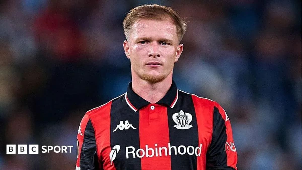 Futbolçu oyun formasında kameraya baxır