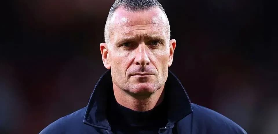 Football coach in a dark jacket on the field