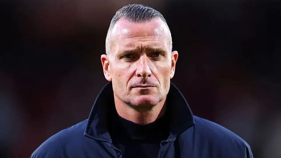 Football coach in a dark jacket on the field