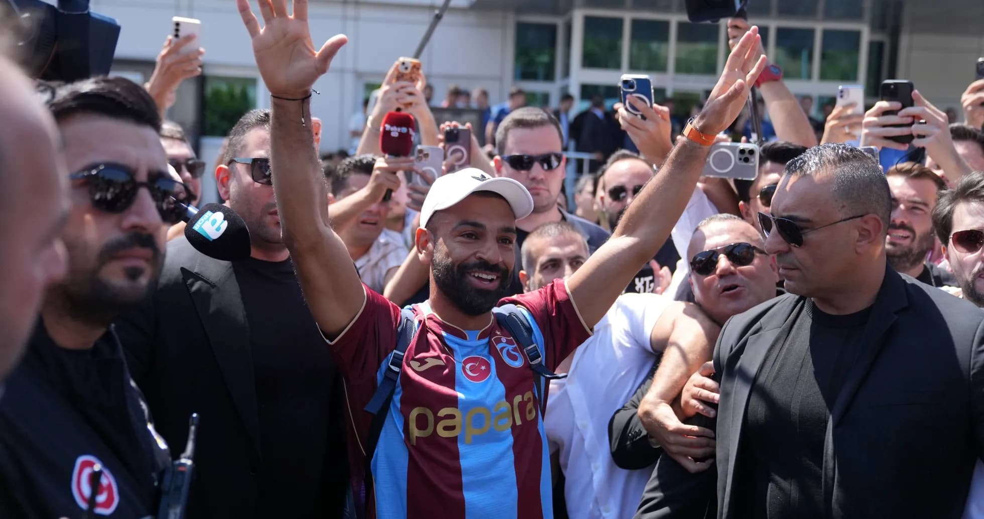 Fan welcoming player in Trabzonspor jersey with crowd