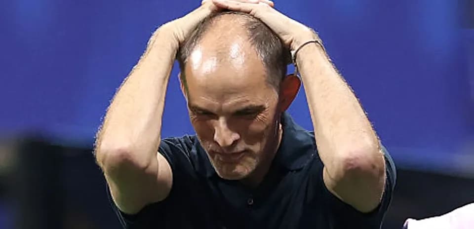 Football coach with hands on head during match
