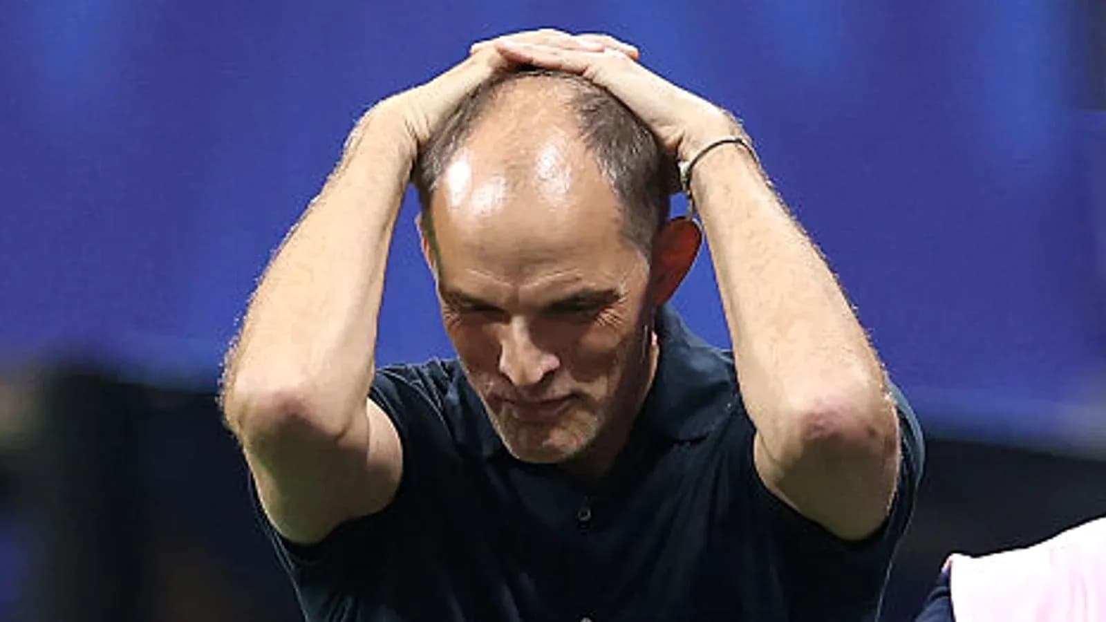 Football coach with hands on head during match