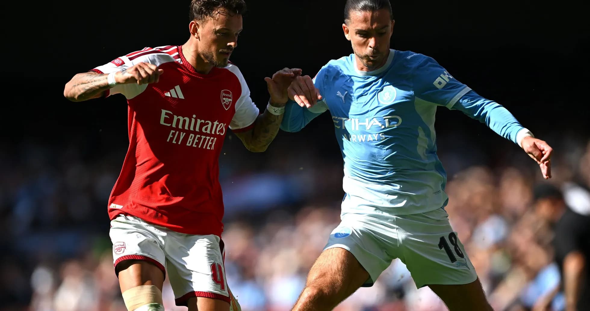 Arsenal and Manchester City players contesting for the ball