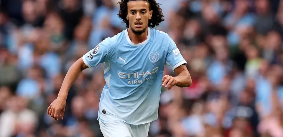 Futbolçu Manchester City formasında topa doğru irəliləyir
