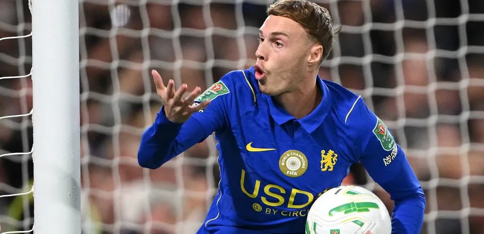Chelsea player gesturing while holding the ball