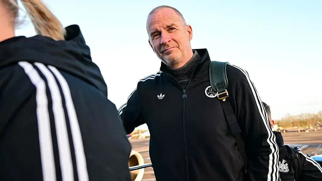 Coach standing at airport with team members