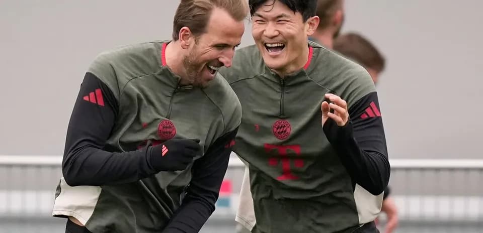 İki futbolçu məşq zamanı gülərək bir-birinə yaxınlaşır