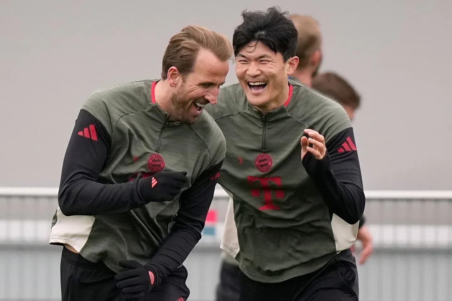İki futbolçu məşq zamanı gülərək bir-birinə yaxınlaşır