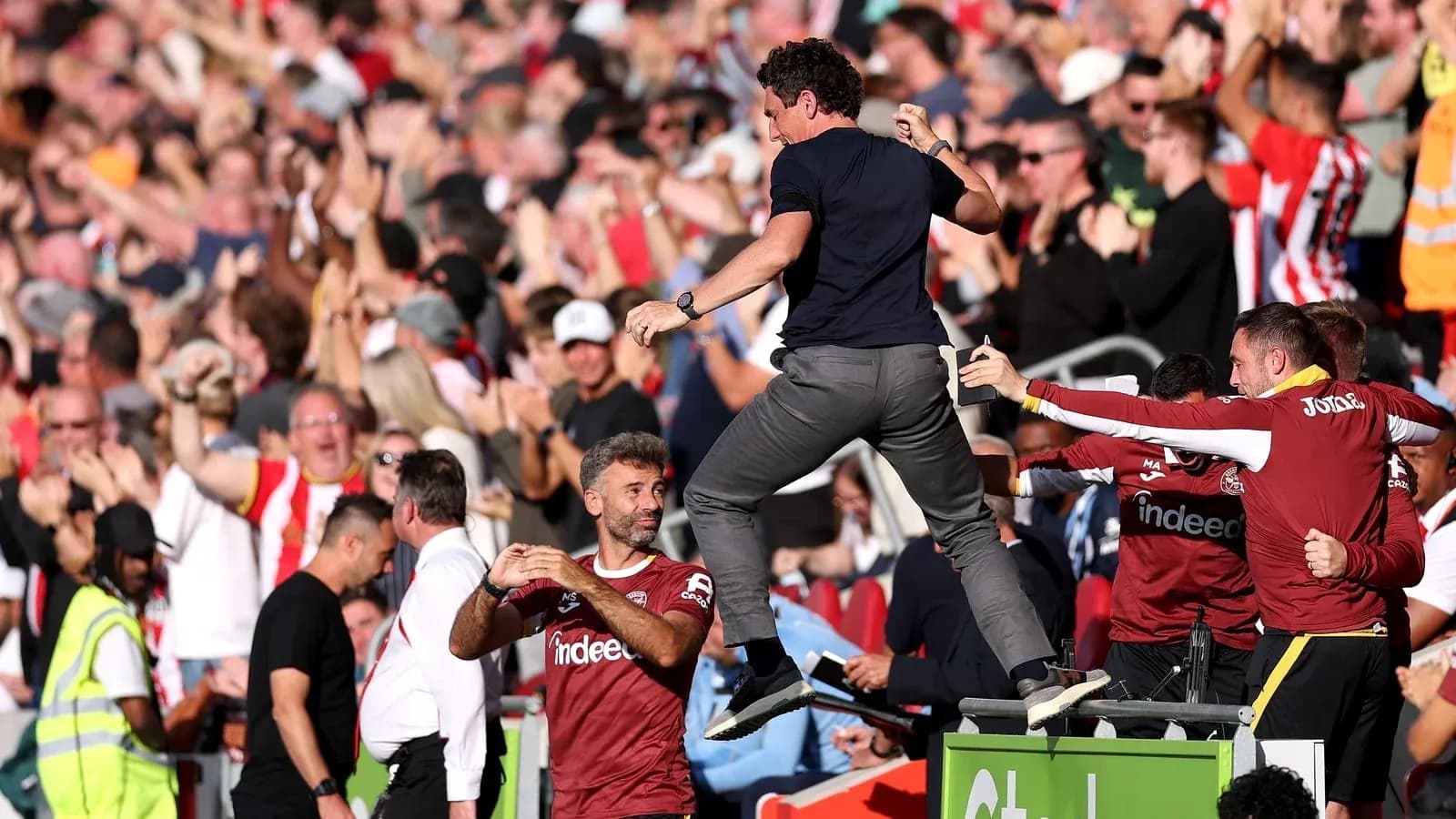 Coach celebrating with fans during a match