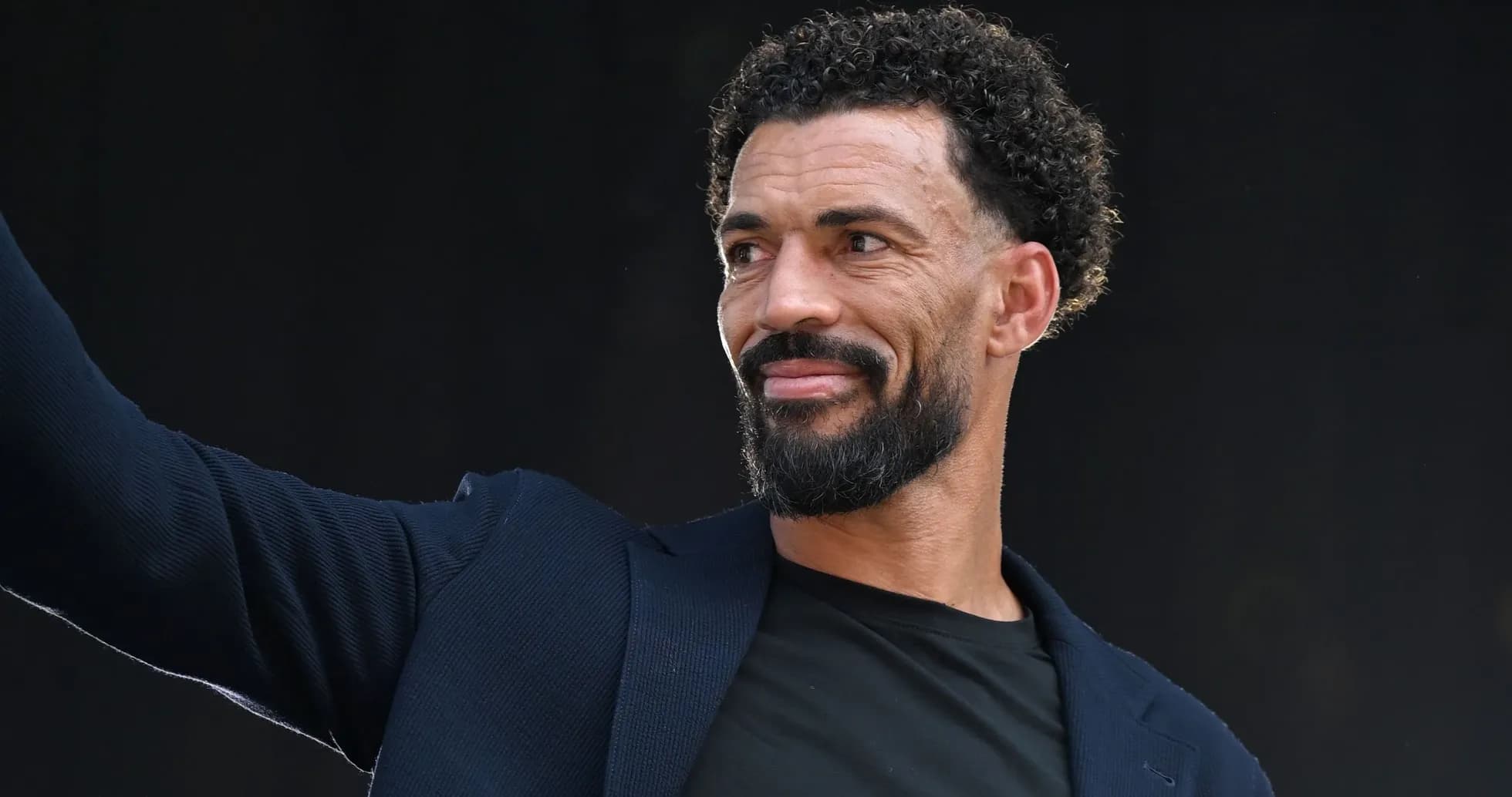 Man in a suit waving at an event