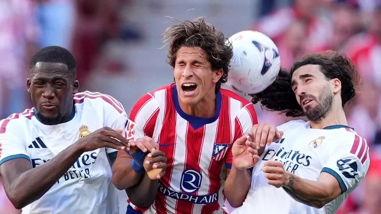 Atletico and Real Madrid players competing for the ball