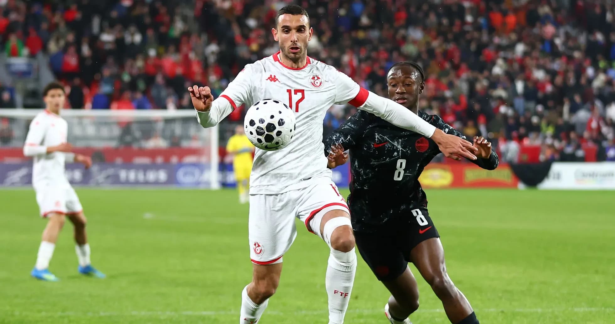 Tunisia player controlling ball against opponent in match