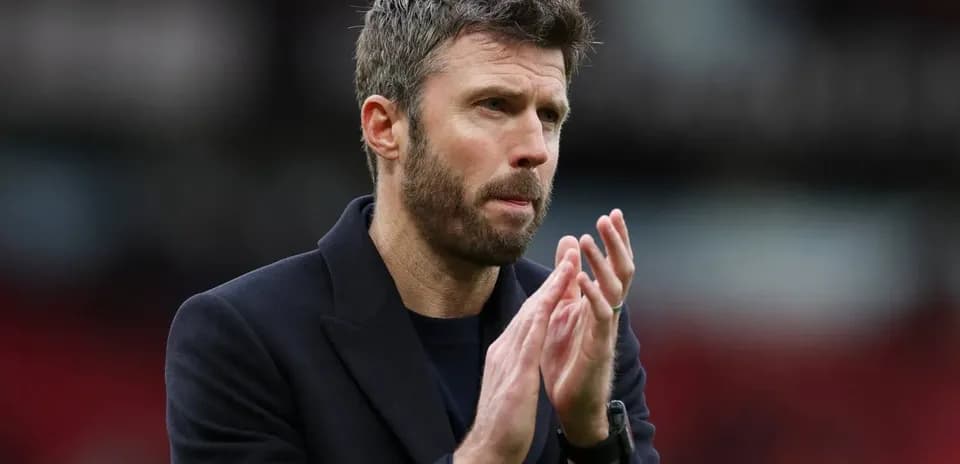 Men's football coach applauding on the pitch